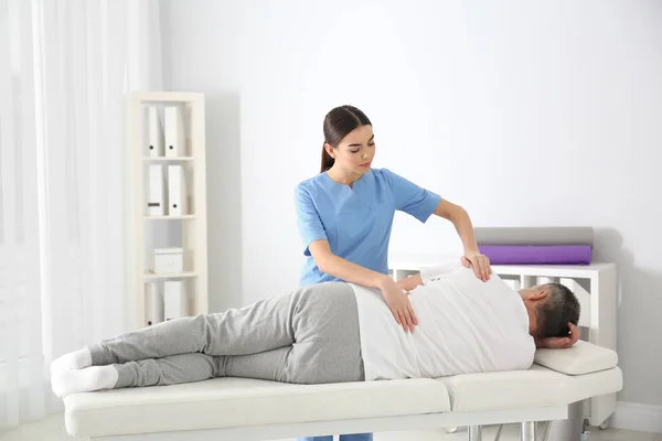 Arts werkzaam met patiënt in het ziekenhuis. Revalidatie massage — Stockfoto