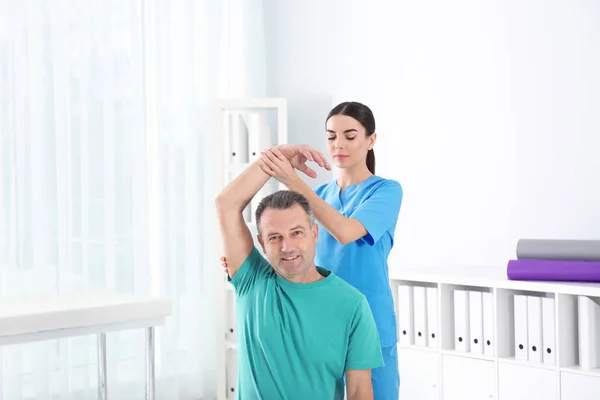 Arts werkzaam met patiënt in het ziekenhuis. Revalidatie fysiotherapie — Stockfoto