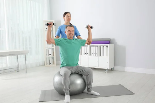 Doctor working with patient in hospital. Rehabilitation exercises — Stock Photo, Image