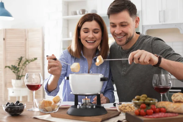Pareja feliz disfrutando de la cena fondue en casa — Foto de Stock