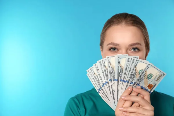 Portrait of young woman with money on color background. Space for text — Stock Photo, Image