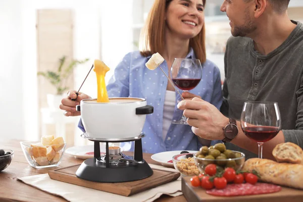 Pareja feliz disfrutando de la cena fondue en casa — Foto de Stock