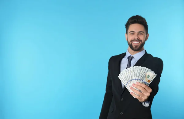 Портрет щасливого молодого бізнесмена з грошима на кольоровому фоні. Простір для тексту — стокове фото