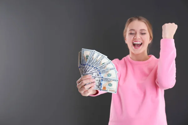 Retrato de una joven emocional con dinero sobre fondo gris. Espacio para texto — Foto de Stock