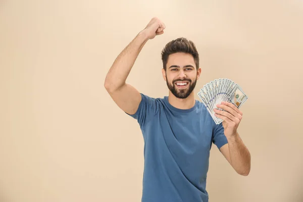 Retrato de un joven feliz con dinero sobre fondo de color. Espacio para texto — Foto de Stock