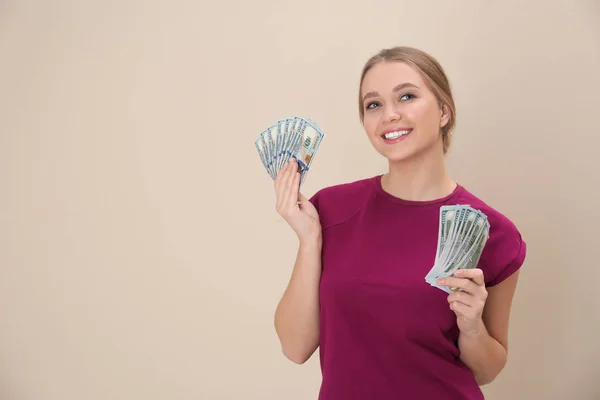 Portret van gelukkige jonge vrouw met geld op de achtergrond in kleur. Ruimte voor tekst — Stockfoto