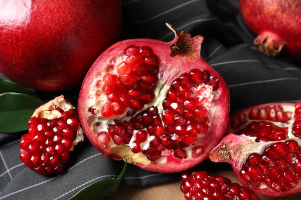 Primer plano de deliciosas granadas rojas maduras con semillas en la servilleta —  Fotos de Stock