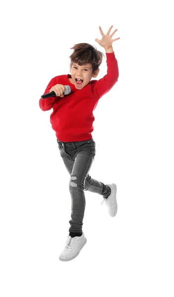 Menino bonito com microfone pulando no fundo branco — Fotografia de Stock