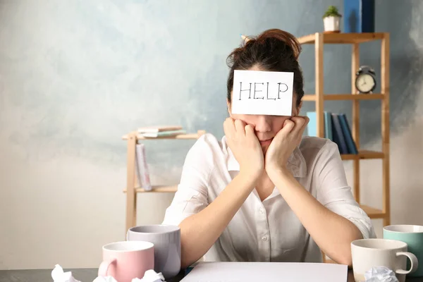 Junge Frau mit Notizblock auf der Stirn am Arbeitsplatz. Raum für Text — Stockfoto