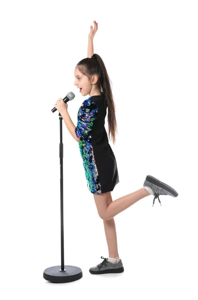 Маленькая девочка поет в микрофон на белом фоне — стоковое фото