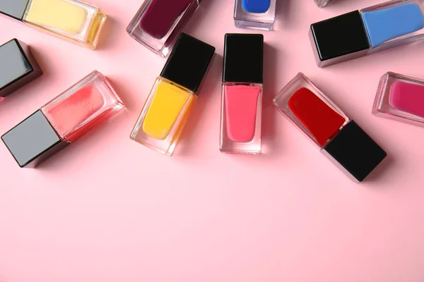 Botellas de esmalte de uñas sobre fondo de color, vista superior con espacio para texto — Foto de Stock