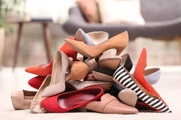 Купа різних взуття на підлозі в кімнаті — стокове фото