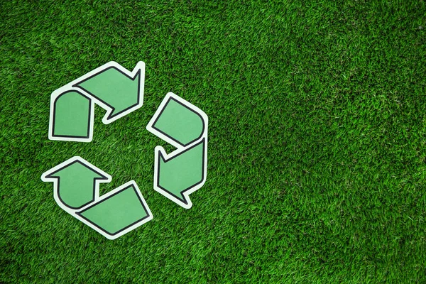 Papier recycling symbool op groen gras, bovenaanzicht. Ruimte voor tekst — Stockfoto