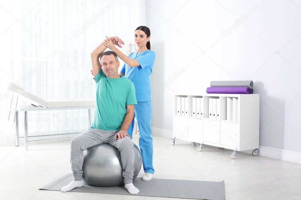 Doctor working with patient in hospital. Rehabilitation exercises