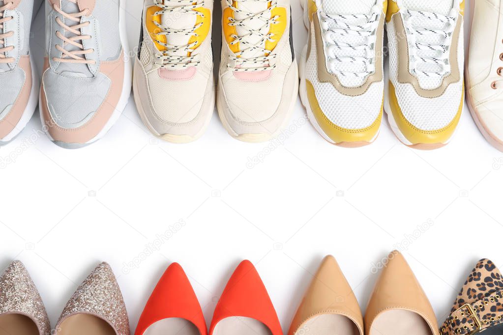 Frame of different shoes on white background, top view with space for text