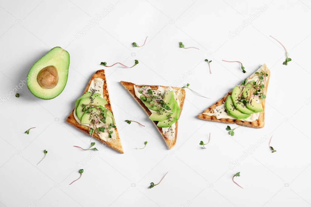 Tasty toasts with avocado, sprouts and chia seeds on white background, top view