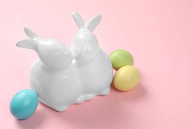 Seramik Easter bunnies ve renk arka plan, metin için yer üzerine boyalı yumurta