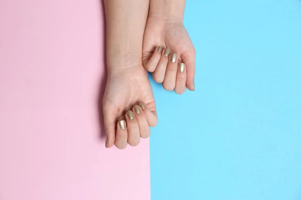 Femme avec manucure dorée sur fond couleur, vue de dessus. Tendances du vernis à ongles — Photo