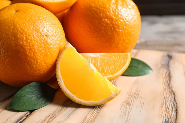 Čerstvé pomeranče s listy na dřevěný stůl, closeup. Prostor pro text — Stock fotografie