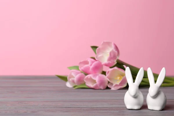 可爱的陶瓷复活节兔子和春天郁金香在木桌上反对颜色背景, 文字空间 — 图库照片