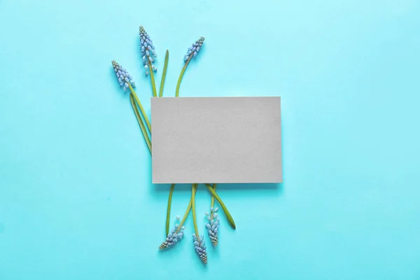 Hermosas flores muscari primavera y la tarjeta en el fondo de color, disposición plana. Espacio para texto —  Fotos de Stock