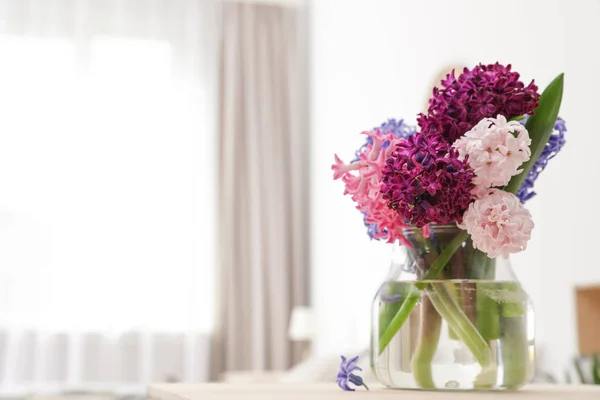 Beautiful hyacinths in glass vase on table indoors, space for text. Spring flowers — Stock Photo, Image