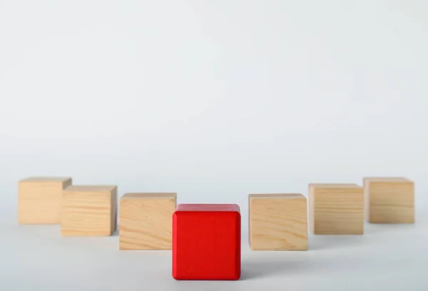 Cubo vermelho na frente dos de madeira sobre fundo branco. Conceito de vitória — Fotografia de Stock