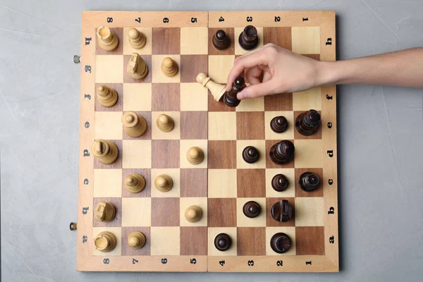 Mujer jugando ajedrez sobre fondo gris, vista superior. Concepto de victoria — Foto de Stock