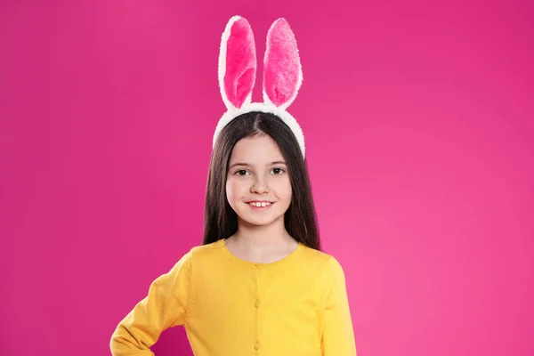 Portrait of little girl in Easter bunny ears headband on color background — Stock Photo, Image