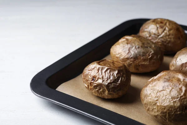 Δίσκος με πατάτες ψημένο σακάκι στο τραπέζι, κοντινό πλάνο — Φωτογραφία Αρχείου