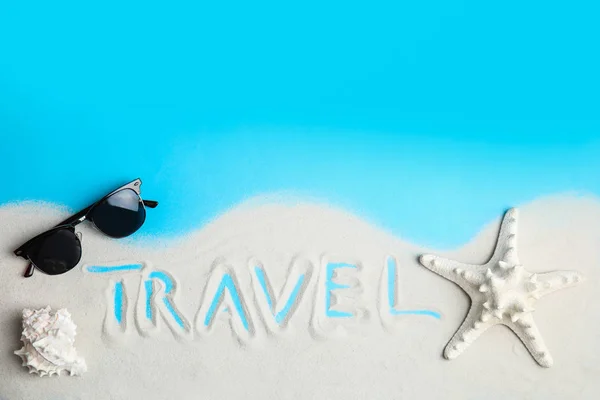 Composição plana com areia, óculos de sol e palavra TRAVEL sobre fundo de cor, espaço para texto. Agência de turismo — Fotografia de Stock