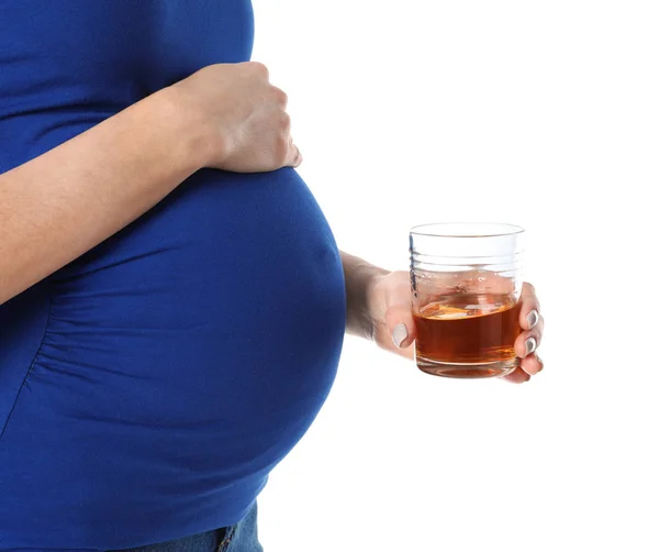Будущая мама со стаканом алкогольного напитка на белом фоне, крупным планом. Плохие привычки во время беременности — стоковое фото