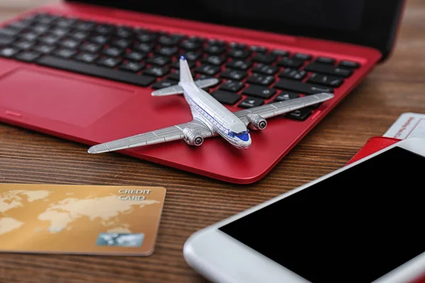 Σύνθεση με αεροπλάνο μοντέλο και laptop σε ξύλινο τραπέζι. Ταξιδιωτικό πρακτορείο έννοια — Φωτογραφία Αρχείου