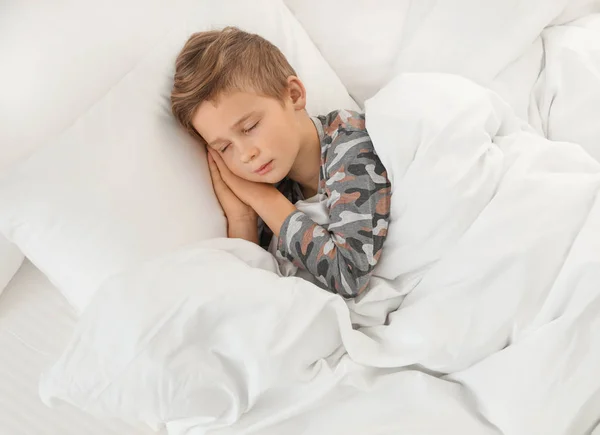 Roztomilý unavený chlapec spí v pohodlné posteli — Stock fotografie