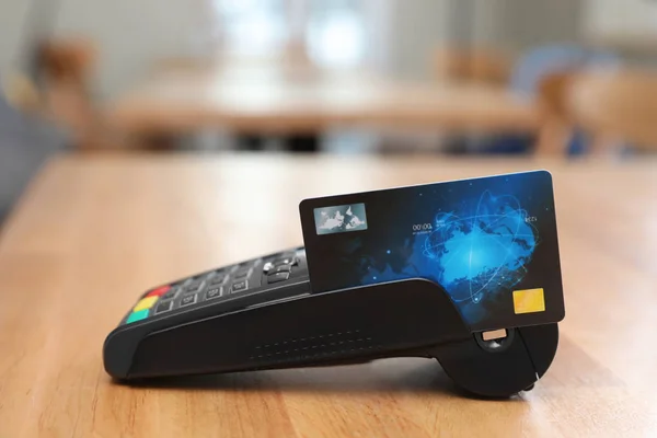 Credit card machine for non cash payment on wooden table indoors