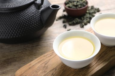 Bardak ve kravat Guan Yin oolong ahşap masa üzerinde çaydanlık. Metin için yer