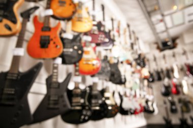 Müzik mağazasında farklı gitarların satırları, bulanık görünüm