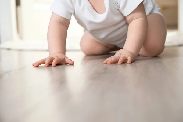 Śliczne małe dziecko pełzające na podłodze w pomieszczeniu, zbliżenie — Zdjęcie stockowe