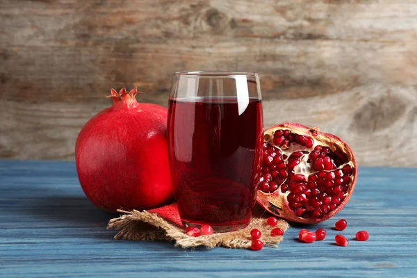 Vaso de jugo de granada y frutas frescas sobre mesa sobre fondo de madera —  Fotos de Stock