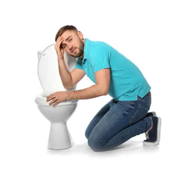 Young man suffering from nausea near toilet bowl isolated on white — Stockfoto