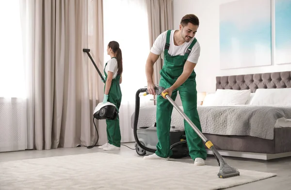 プロの機器との清掃担当者のクリーニングベッドルームのチーム — ストック写真
