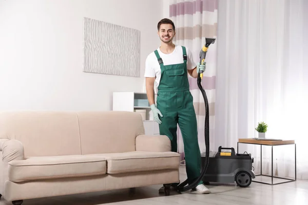 Professional janitor cleaning sofa in living room — Stock Photo, Image