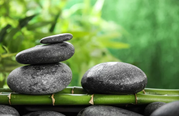 Zen stones on bamboo against blurred background — Stock Photo, Image