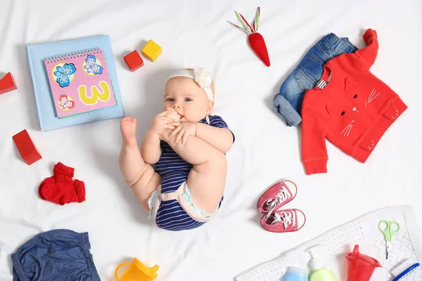 Niedliches kleines Baby mit Kleidung und Accessoires auf weißem Hintergrund, Ansicht von oben — Stockfoto