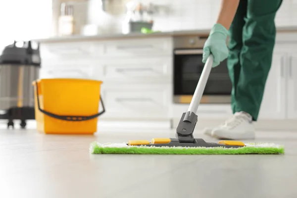 Petugas kebersihan profesional membersihkan lantai dengan pel di dapur, closeup — Stok Foto