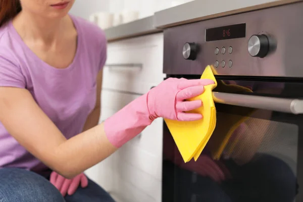 妇女清洁烤箱与抹布在厨房, 特写镜头 — 图库照片
