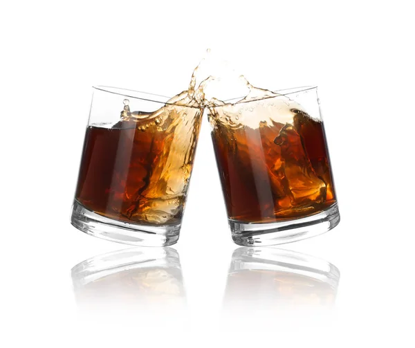 Glasses of expensive whiskey clinking together and splashing on white background — Stock Photo, Image