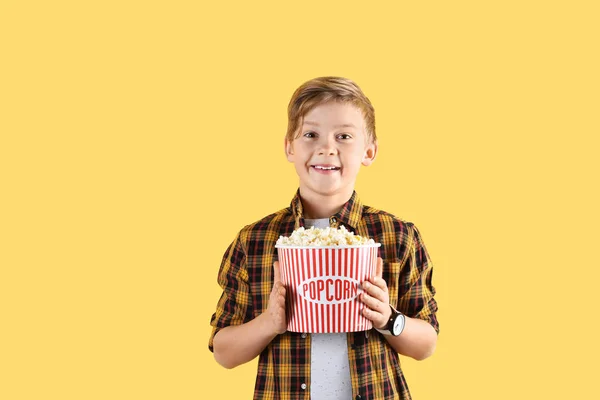 Милий хлопчик з попкорн відром на кольоровому фоні — стокове фото