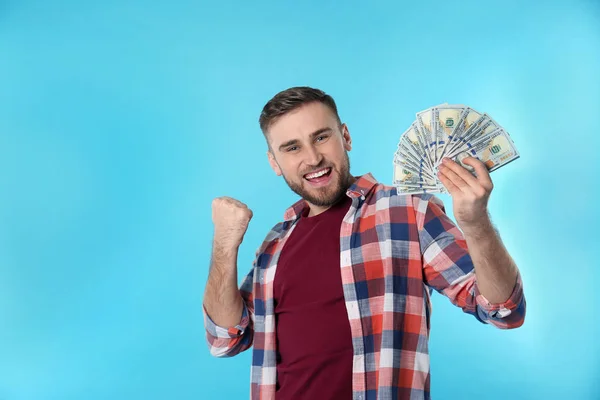 Portrait of happy young man with money on color background. Space for text — Stock Photo, Image