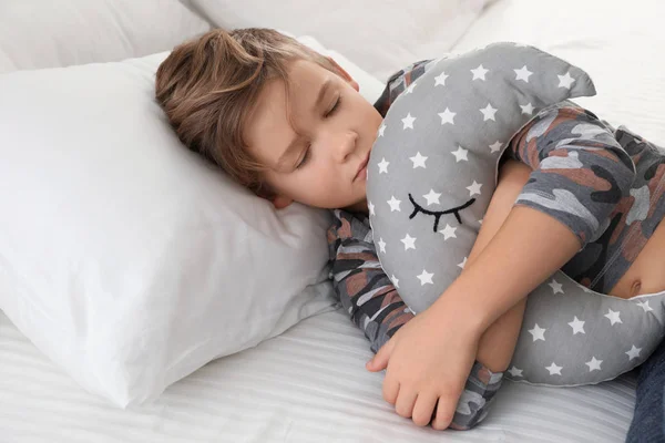 Симпатичный мальчик с игрушкой спит в постели — стоковое фото